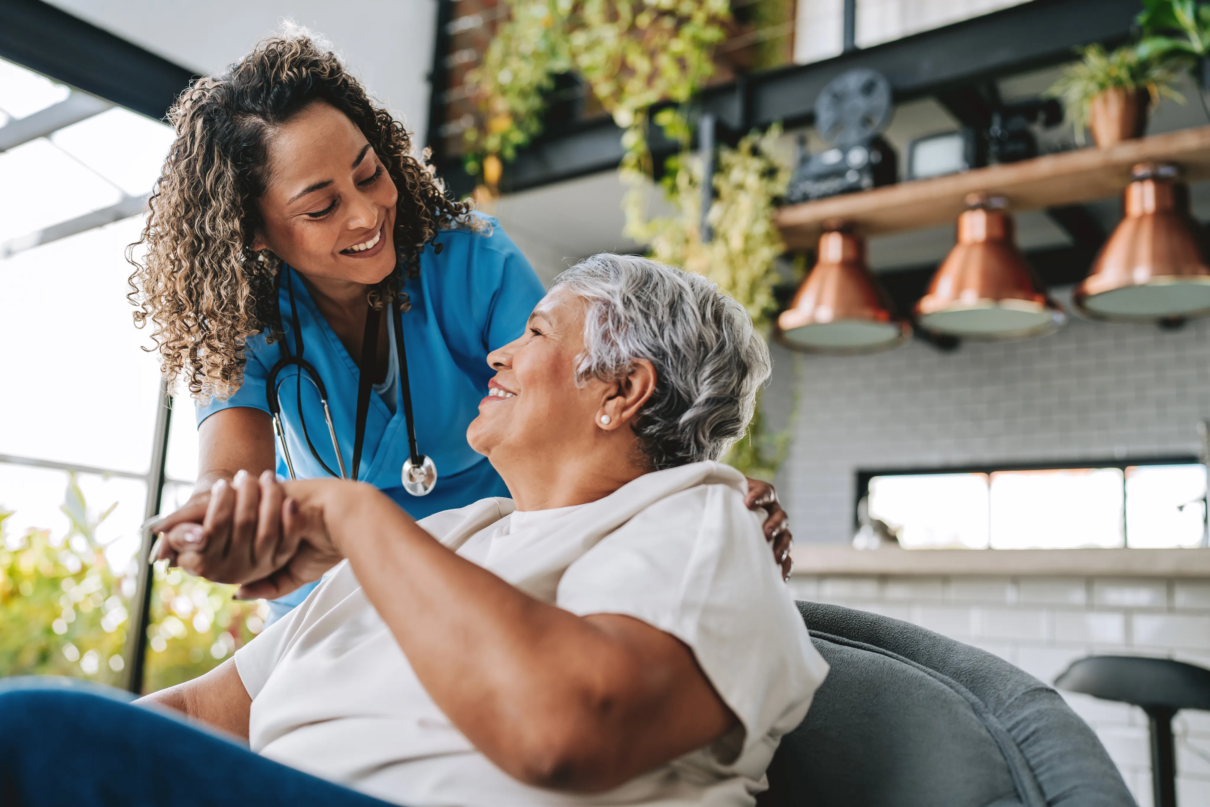 A caregiver holding hands with an elderly woman