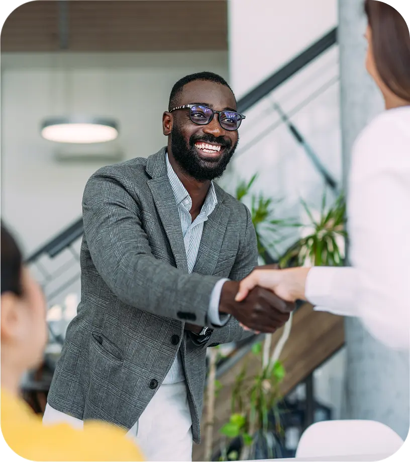Wellcove team member shaking hands with a carrier partner in a bright office